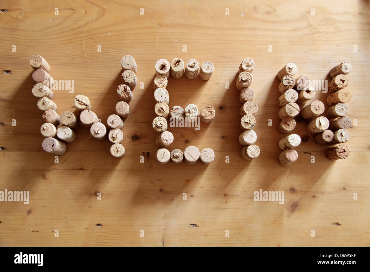 I tappi di sughero formante la parola vino sulla scrivania in legno Foto Stock