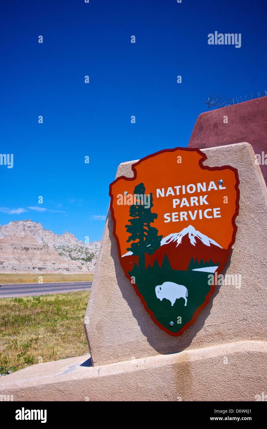 Un servizio del Parco Nazionale segno sorge lungo una strada nel Parco nazionale Badlands. Foto Stock