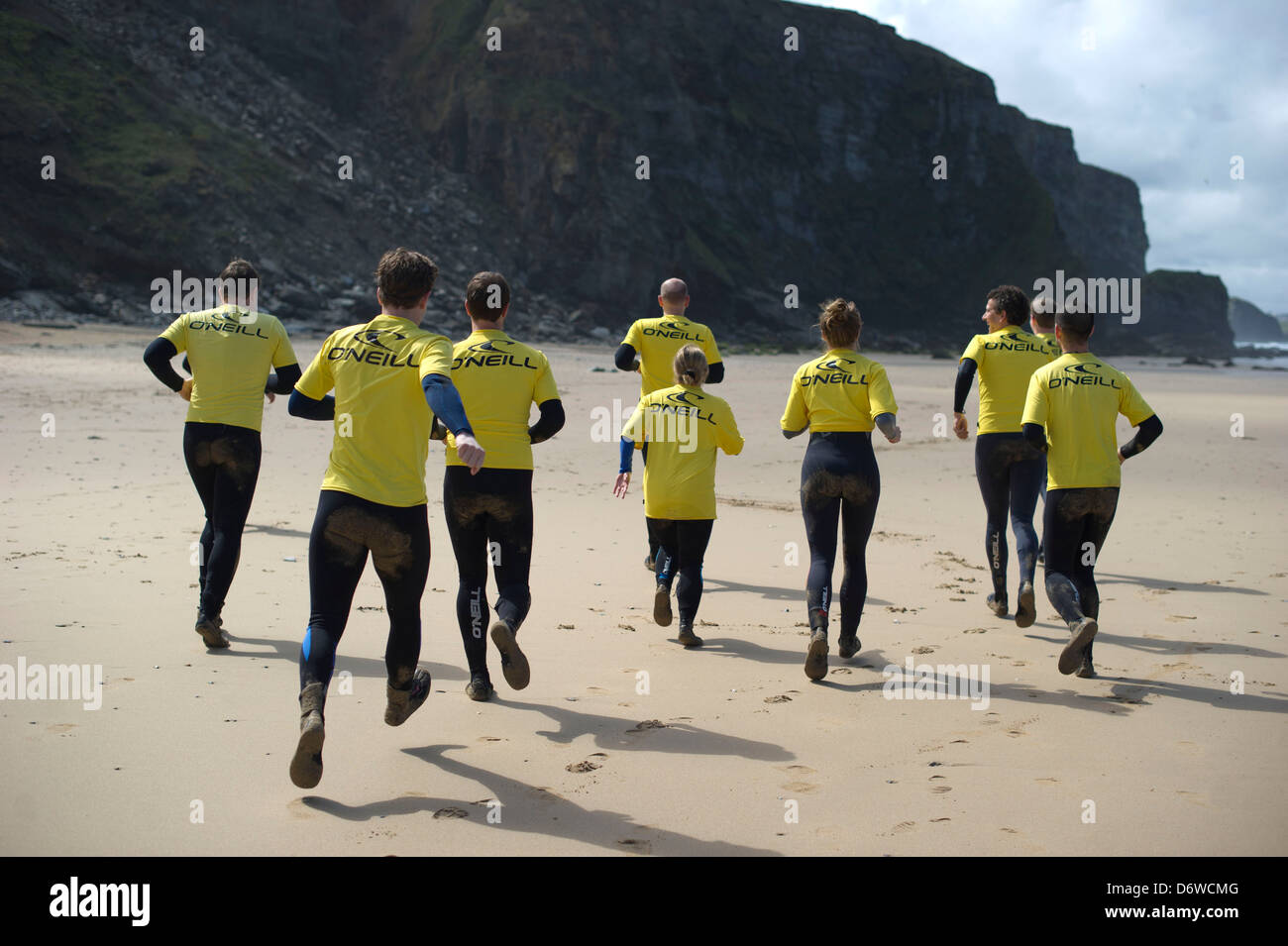 In fase di riscaldamento per una lezione di surf sulla spiaggia di Watergate Bay, Cornwall, Regno Unito Foto Stock