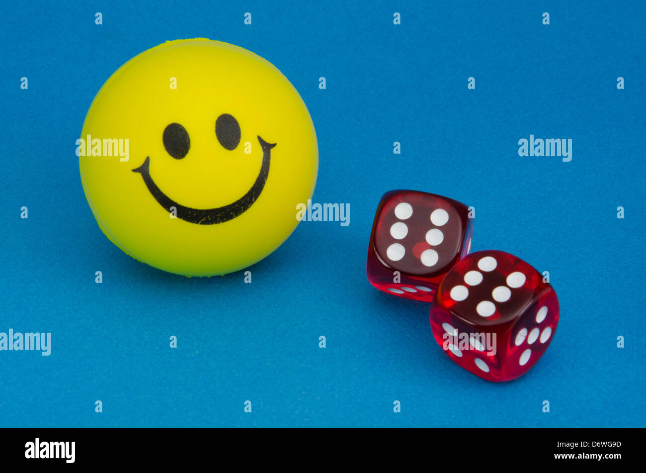 Felice giallo Smiley face con una coppia di dadi rossi che mostra un rotolo di dodici Foto Stock