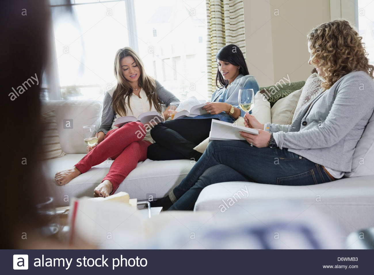 Donne mature la lettura di libri durante house party Foto Stock