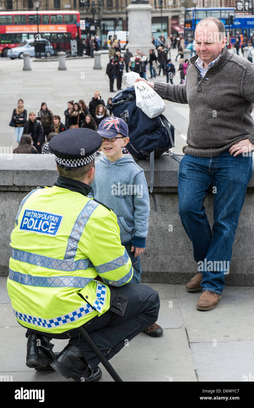 Un giovane ragazzo che parla con un ufficiale metropolitano della polizia. Foto Stock