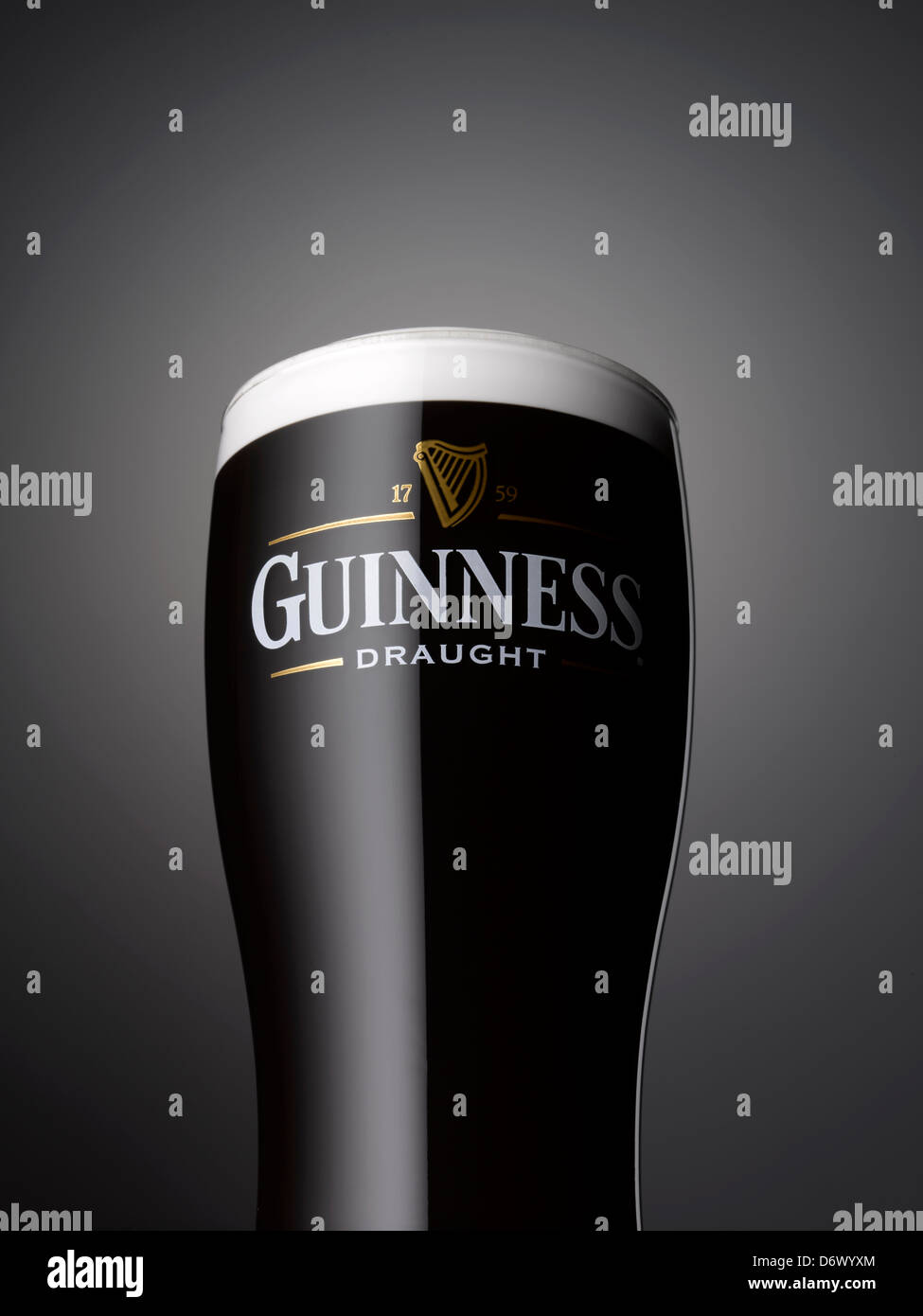Un'immagine ravvicinata di una pinta di Guinness su sfondo grigio Foto Stock