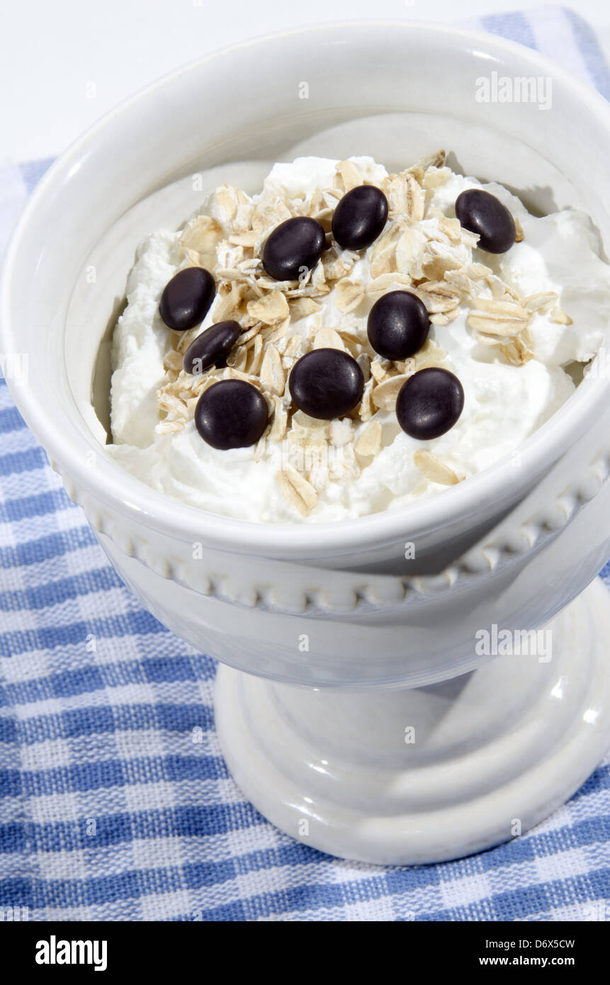 Lo yogurt naturale con le lenticchie di cioccolato in una ciotola vintage Foto Stock