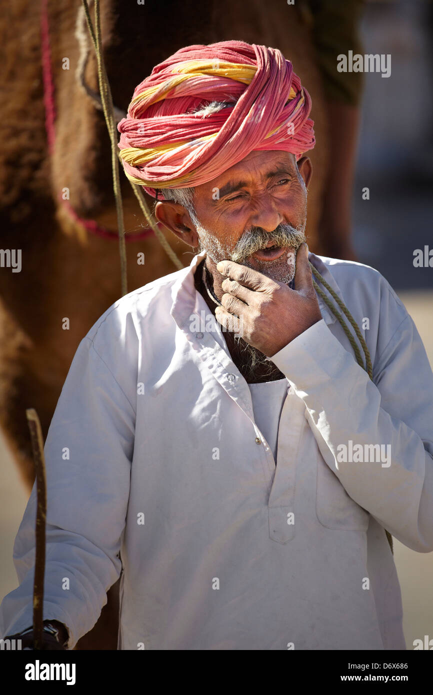 Ritratto di india uomo camel rider indossando turbante rosso, Bishnoi, India Foto Stock