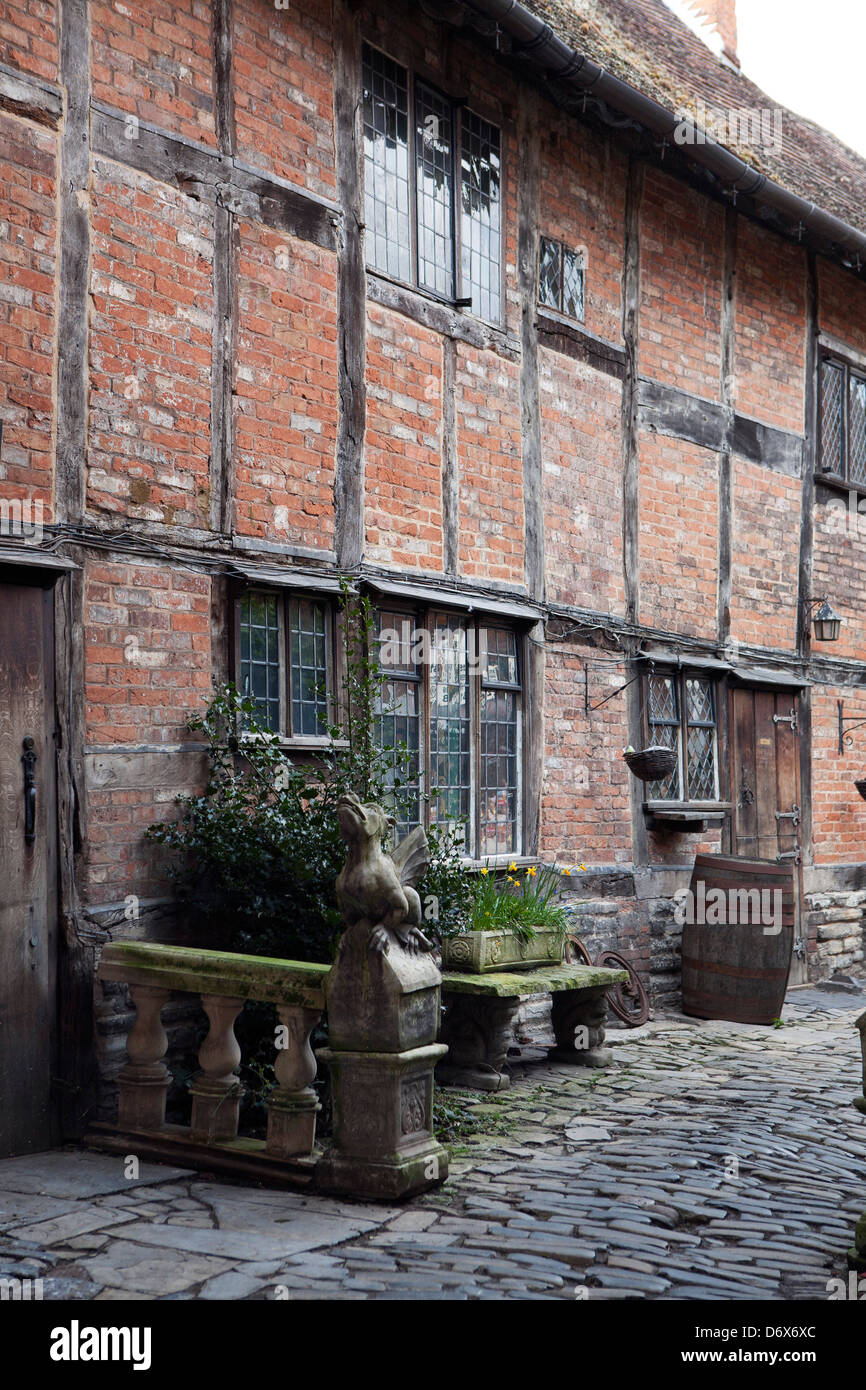 Sheep Street. Storico in mattoni e legno edifici a Stratford upon Avon. Strada di ciottoli con una statua di pietra di un animale. Foto Stock