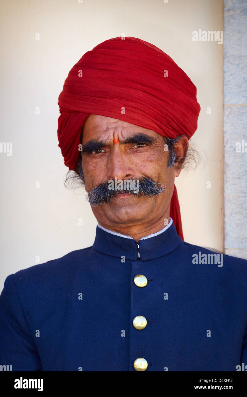 Ritratto di una India guard uomo con i baffi indossando turbante rosso, City Palace di Jaipur, Rajasthan, India Foto Stock