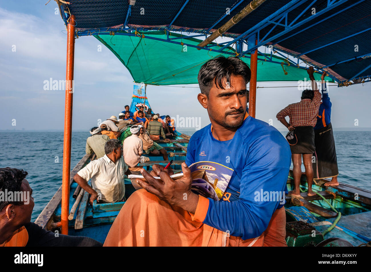 Fisherman fa i conti come equipaggio fissati su un viaggio di pesca in una barca da Mapilla Bay Harbor in Kannur, Kerala, India. Foto Stock