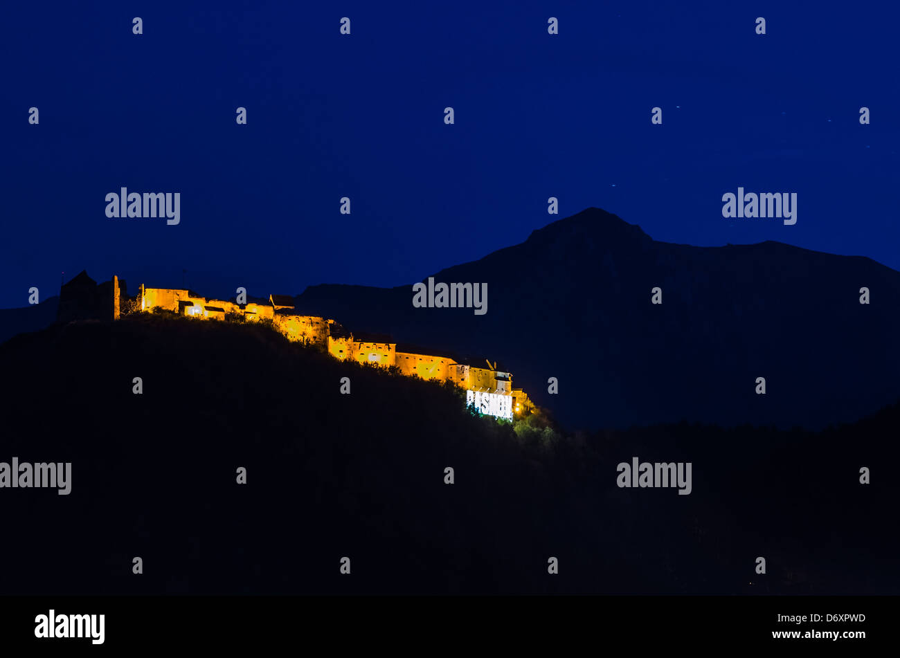 Vista notturna della fortezza Rasnov dalla distanza Foto Stock