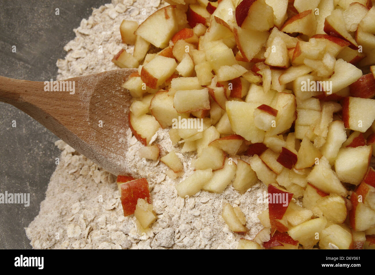 Tagliate le mele rosse nella ciotola di porridge di avena e la farina Foto Stock