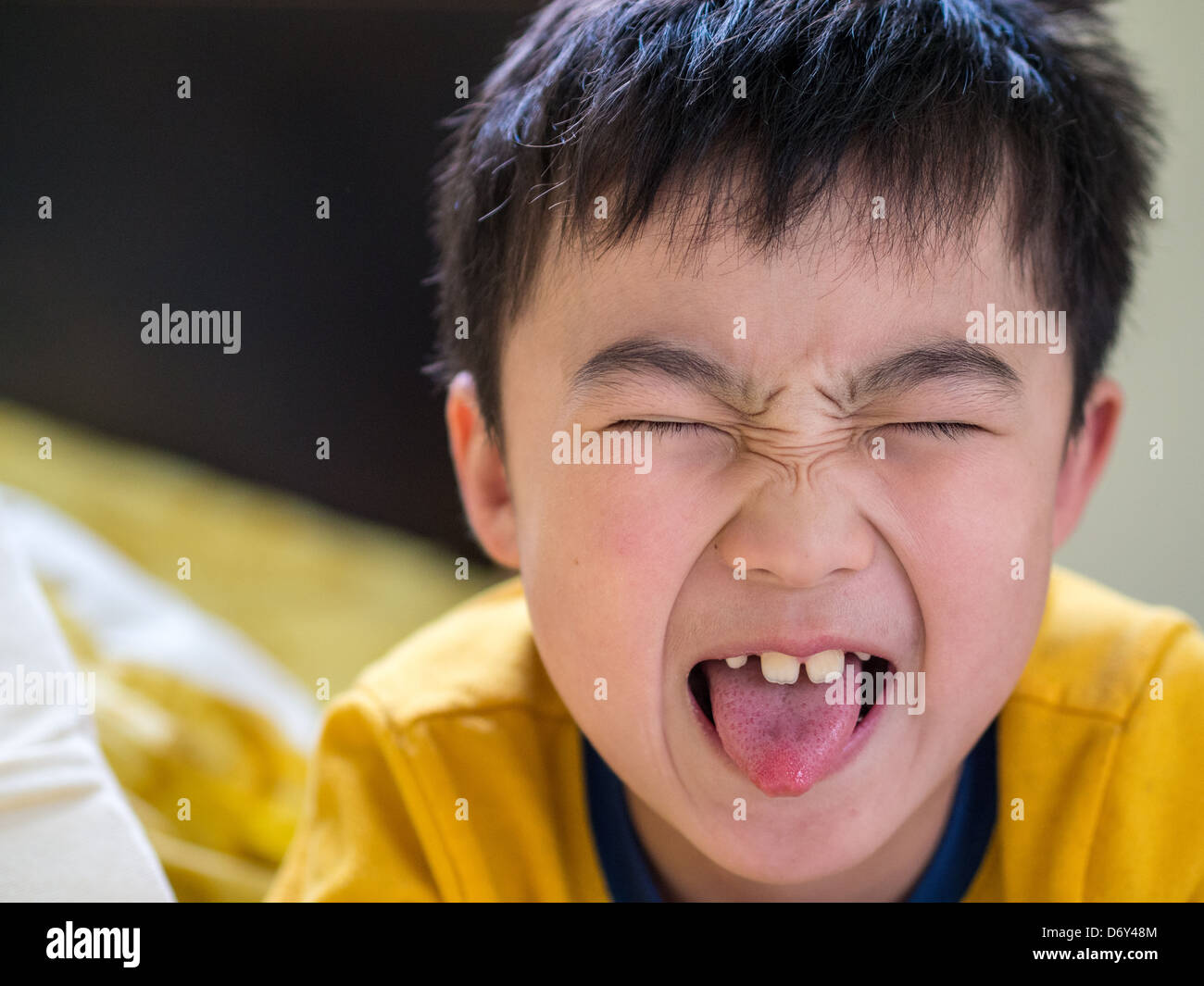 Grande Ritratto di giovane ragazzo asiatico smorfie. Foto Stock