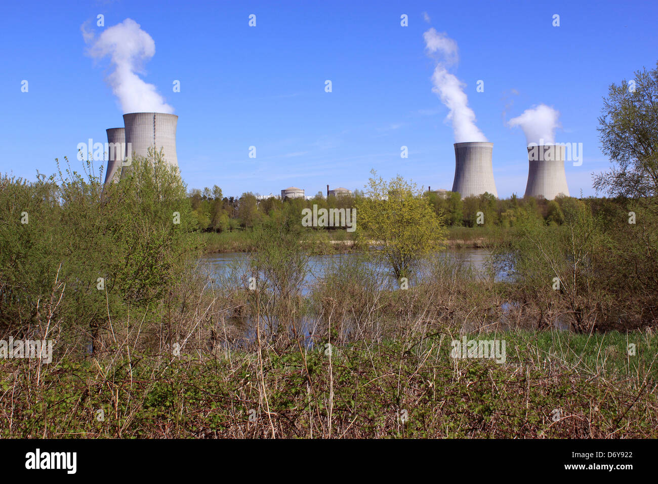 Foto di un impianto ad energia nucleare sulle rive di un fiume circondato da alberi Foto Stock