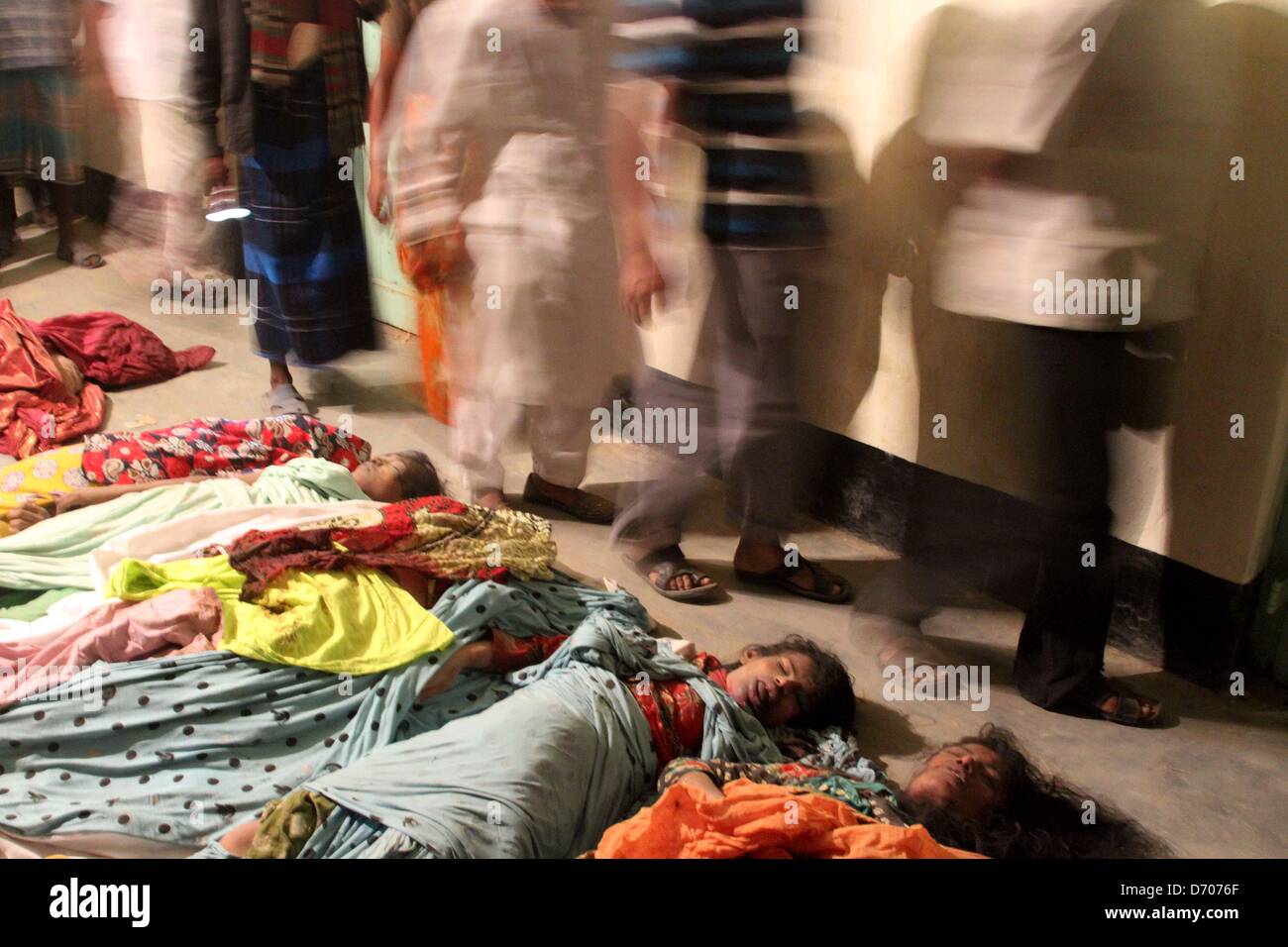 Popolo del Bangladesh identificare i corpi dei loro parenti che sono morti nel crollo dell'edificio in Savar, nella periferia di Dhaka, il 25 aprile 2013. Un edificio di otto piani contenenti diverse fabbriche di indumento è crollata in Bangladesh, uccidendo almeno 216 persone e ulteriormente evidenziando problemi di sicurezza nel settore dell'abbigliamento. Armati con frese in calcestruzzo e gru, centinaia di vigili del fuoco ed esercito soccorritori faticato a trovare superstiti nella montagna di cemento e acciaio mangled, che assomigliava a seguito di un terremoto. Foto Stock