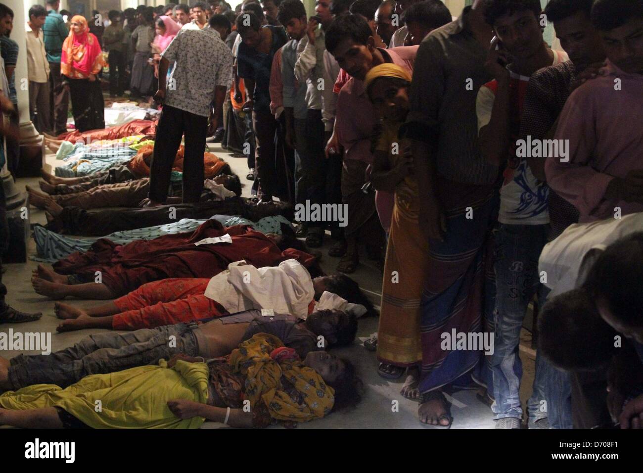 Savar, Bangladesh. Aprile 25, 2013. Popolo del Bangladesh identificare i corpi dei loro parenti che sono morti nel crollo dell'edificio in Savar. Un edificio di otto piani contenenti diverse fabbriche di indumento è crollata in Bangladesh, uccidendo almeno 216 persone e ulteriormente evidenziando problemi di sicurezza nel settore dell'abbigliamento. Armati con frese in calcestruzzo e gru, centinaia di vigili del fuoco ed esercito soccorritori faticato a trovare superstiti nella montagna di cemento e acciaio mangled, che assomigliava a seguito di un terremoto. Foto Stock