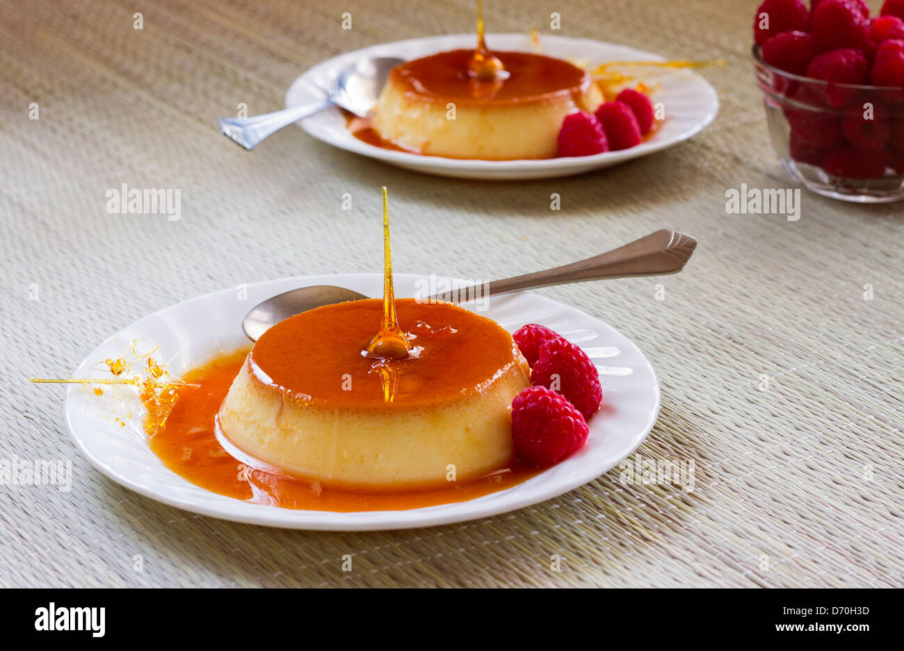 In casa gustosi dessert Flan o creme caramel dessert con lamponi. Foto Stock