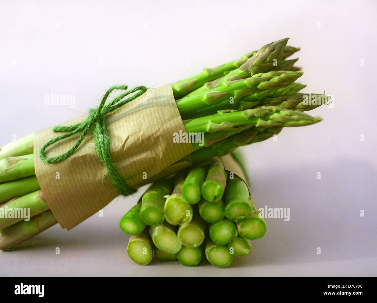 Due fasci di tagliare gli asparagi spears legato con carta marrone e la stringa Foto Stock