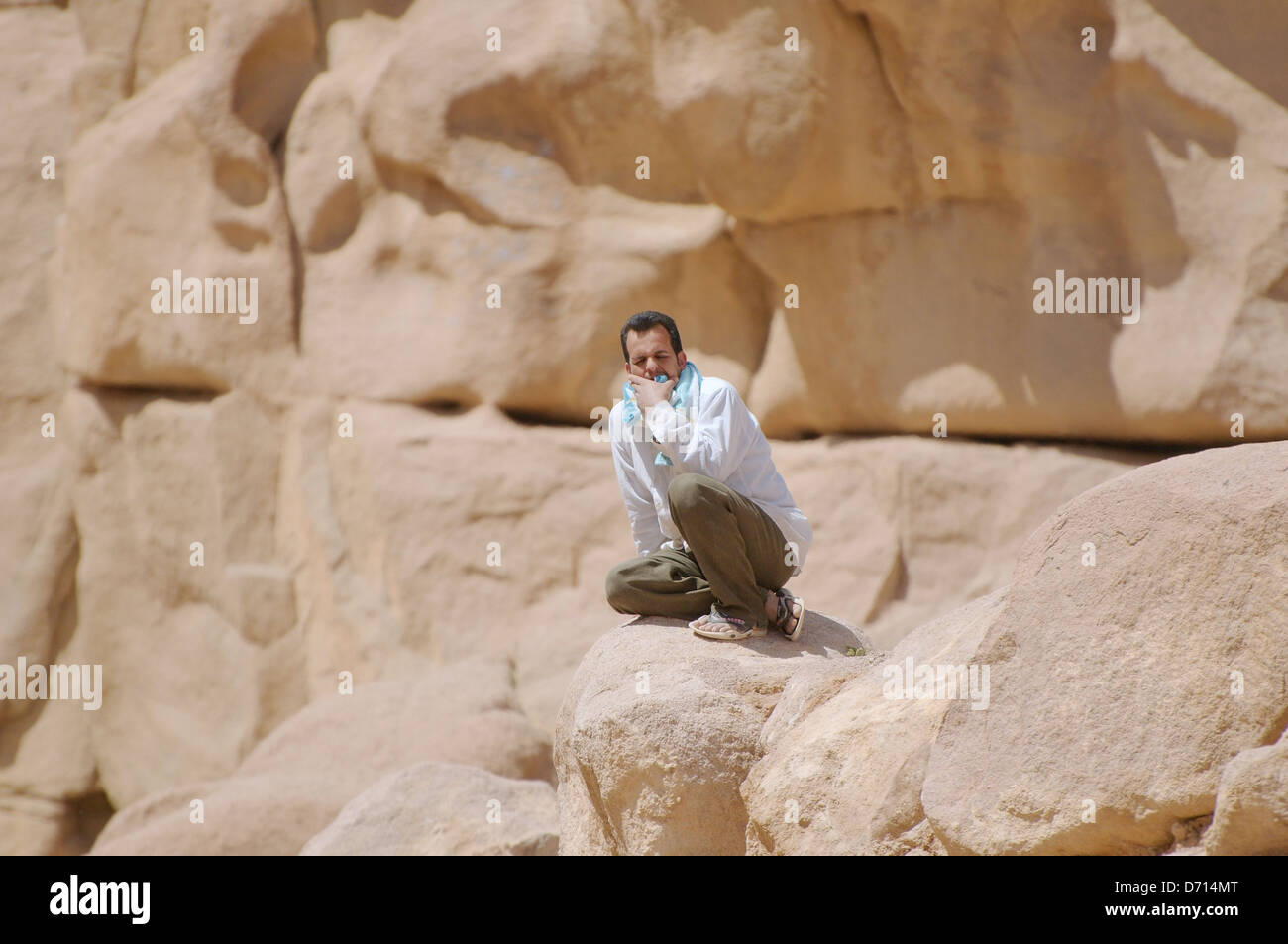 L'uomo arabo siede su una roccia, la penisola del Sinai, l'Egitto Foto Stock