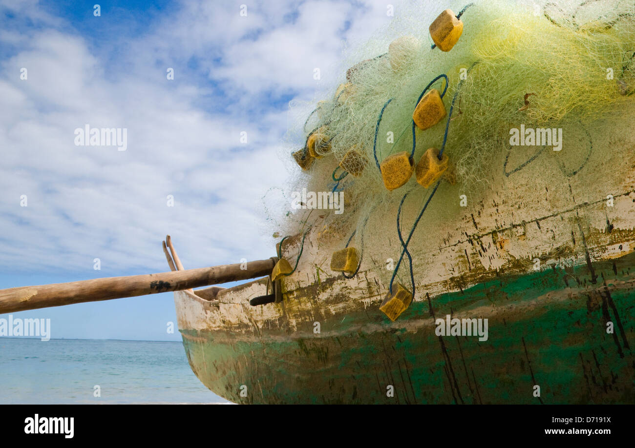 Canoa e rete da pesca sulla spiaggia a Nosy Be, Madagascar Foto Stock