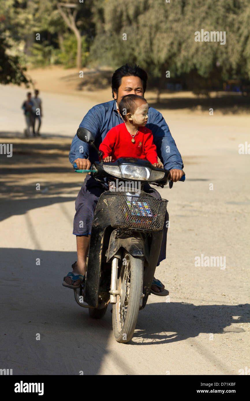 Padre e figlio a cavallo su un ciclomotore a Bagan, Myanmar Foto Stock