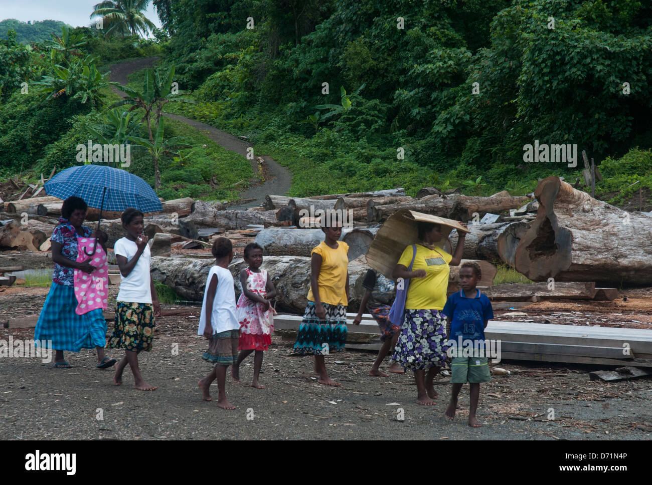 Gli abitanti del villaggio camminano verso la chiesa attraverso un campo di disboscamento malese abbandonato, isola di Makira (San Cristobal), provincia di Makira-Ulawa, Isole Salomone Foto Stock