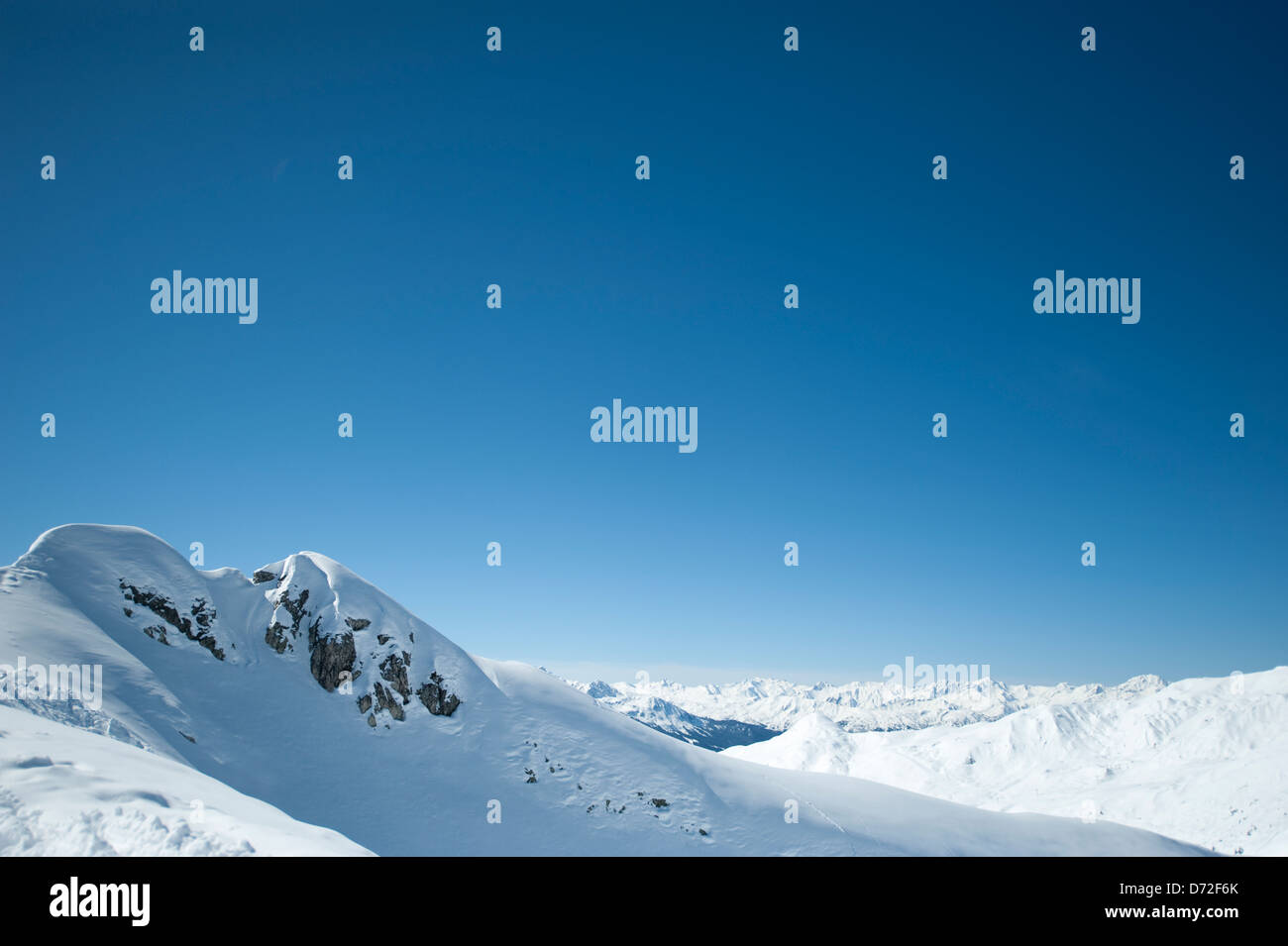 Coperte di neve montagna alpina e cielo blu di altitudine con vista distante Foto Stock