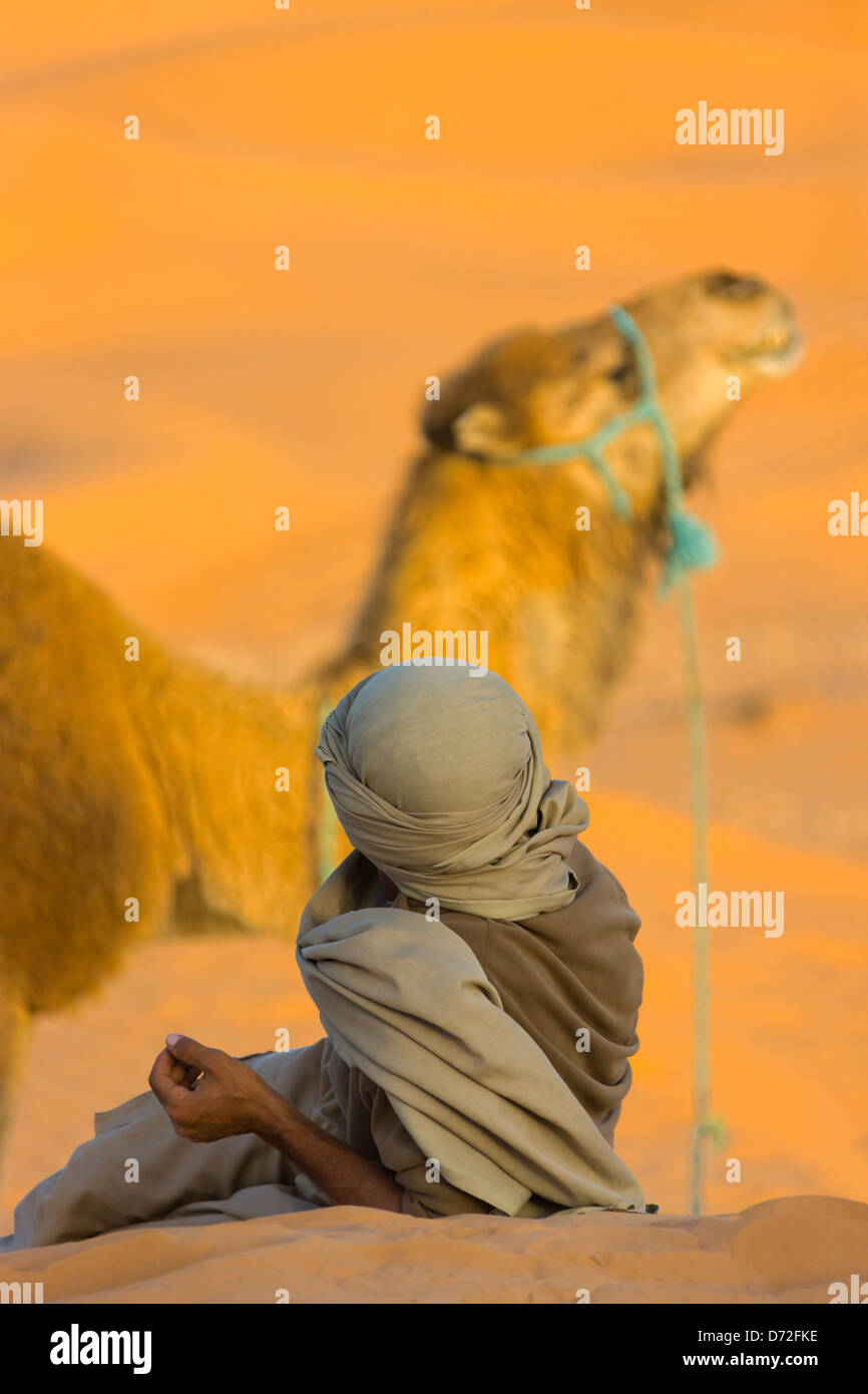 Uomo con cammello nel deserto del Sahara, Ksar Ghilane, Tunisia Foto Stock