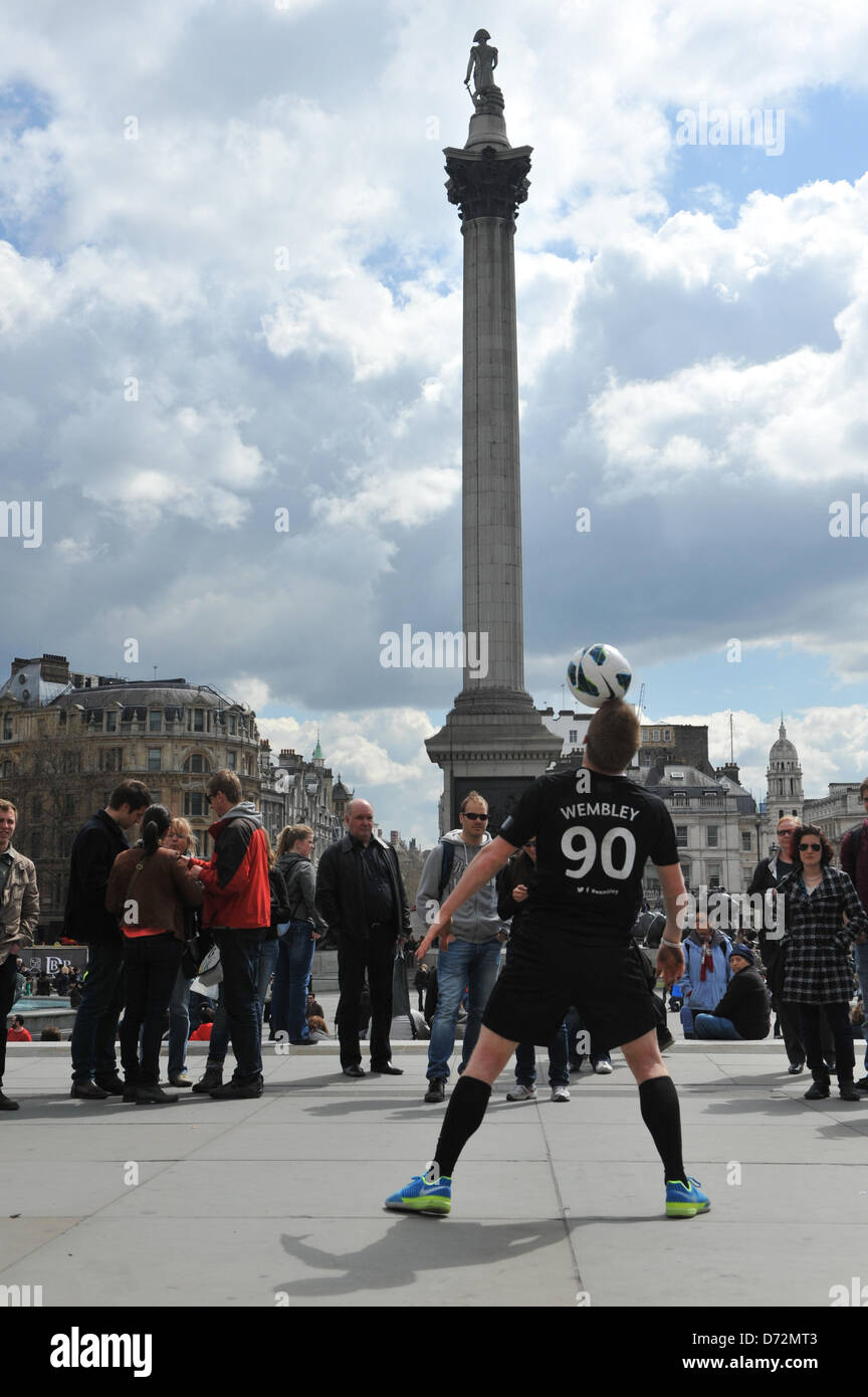 Trafalgar Square, Londra, Regno Unito. Il 27 aprile 2013. Un 'Freestyler' indossando un Wembley 90 shirt intrattiene la Folla a Trafalgar Square. 90 anni di Wembley è celebrato come questo anni finale di FA Cup Match Ball è preso intorno a Londra per terminare a Wembley Stadium, con i giocatori e freestylers intrattenere la folla che hanno dato la possibilità di vedere la FA Cup e match ball su una facciata trasparente carrello. Credito: Matteo Chattle/Alamy Live News Foto Stock