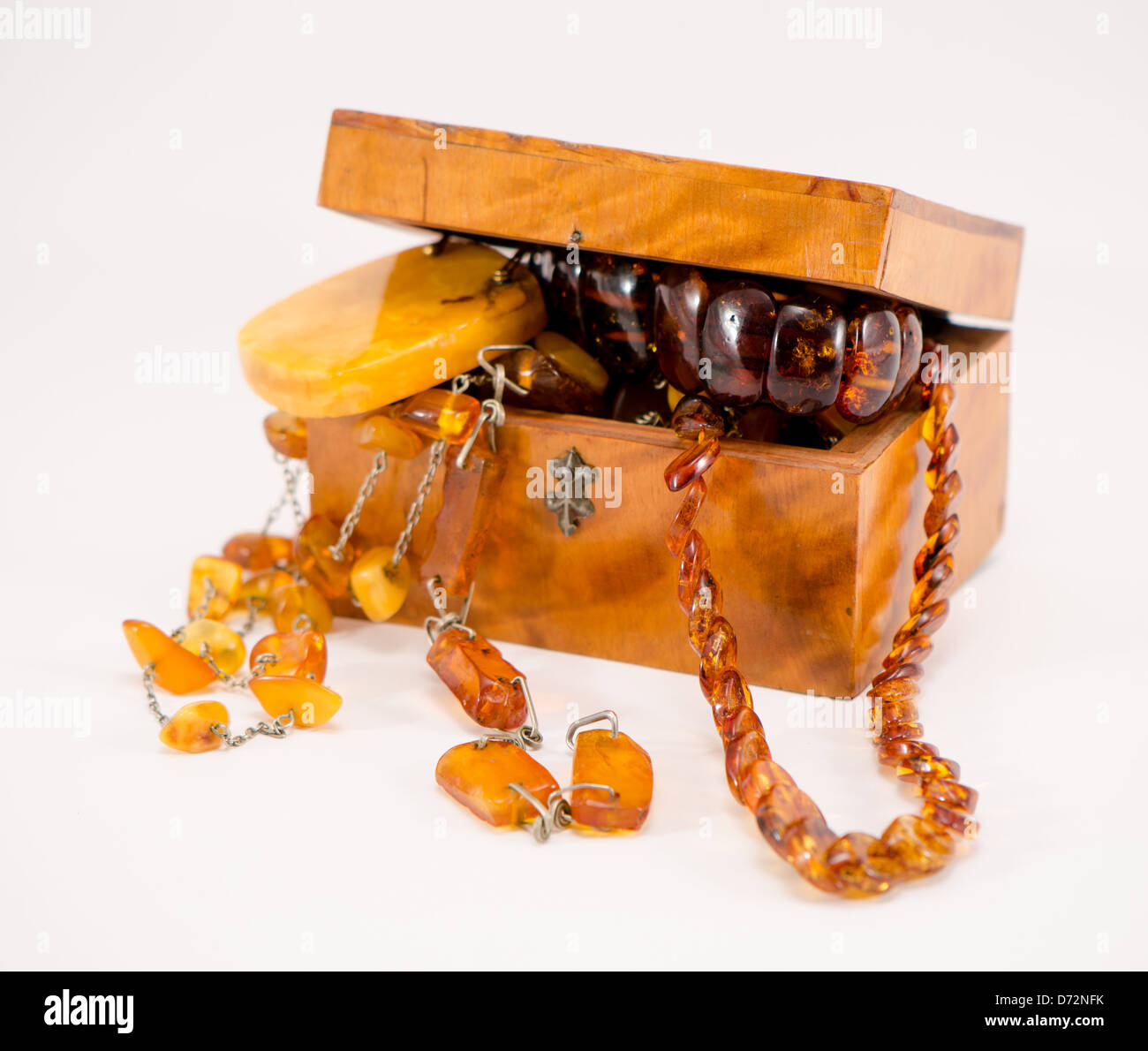 Pietra di ambra gioielli abbigliamento vintage in cassetta di legno petto isolato su bianco. Foto Stock
