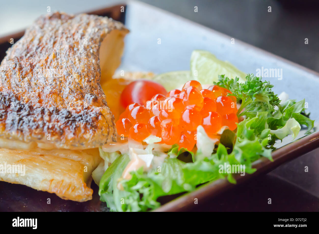 Chiudere il pesce uova Con insalata e grigliate di pesce cod Foto Stock