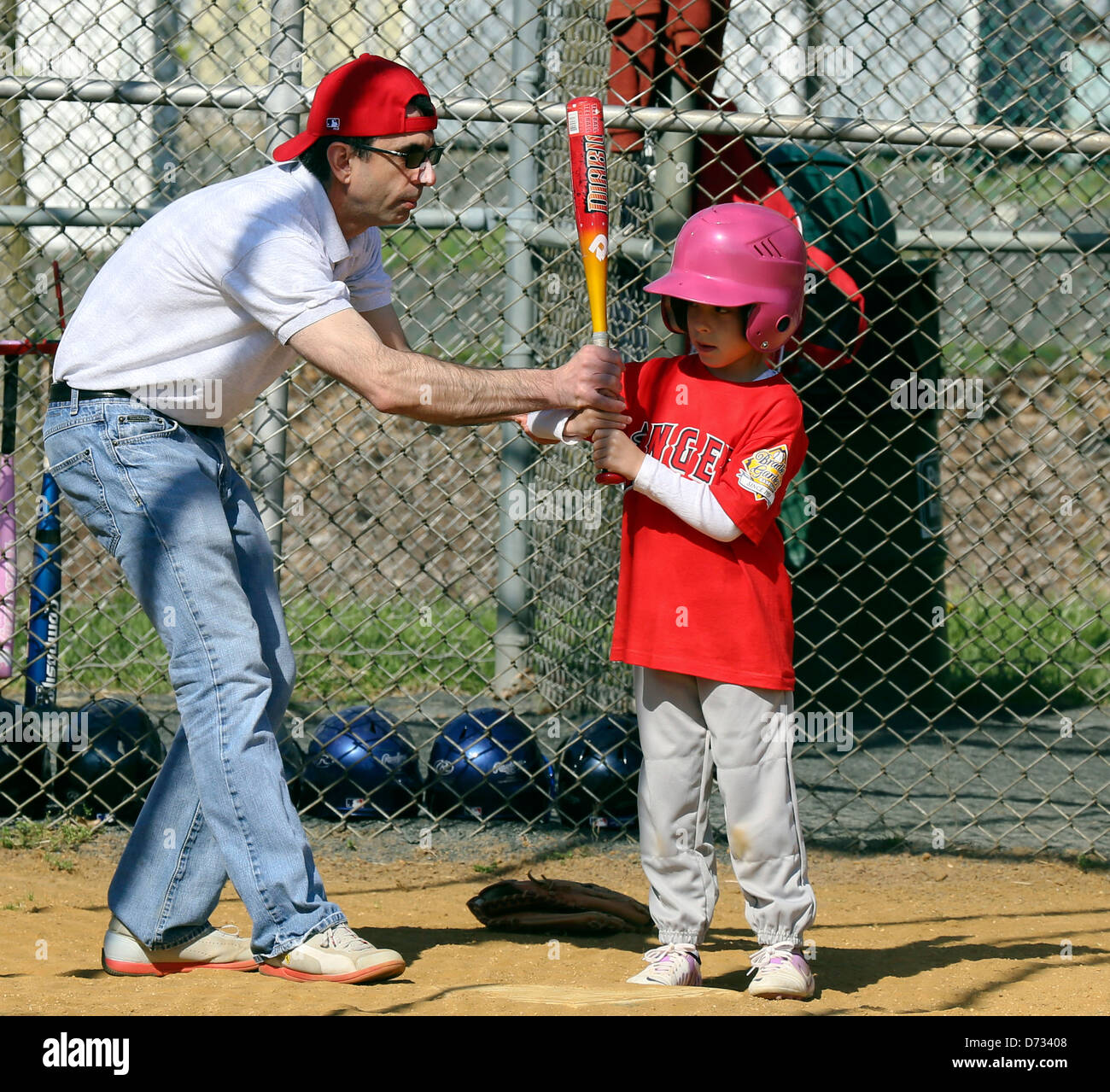 Coach manager ovatta di insegnamento a un raccordo a t t a sfera con sfera di giocatore di baseball. Foto Stock