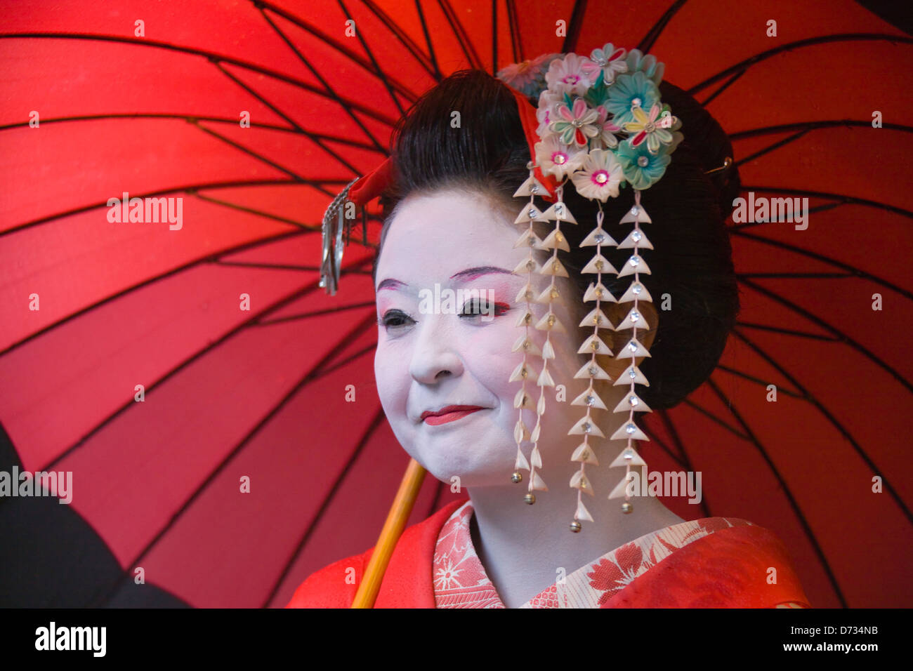 Geisha in kimono con ombrellone rosso, Asakusa, Tokyo, Giappone Foto Stock