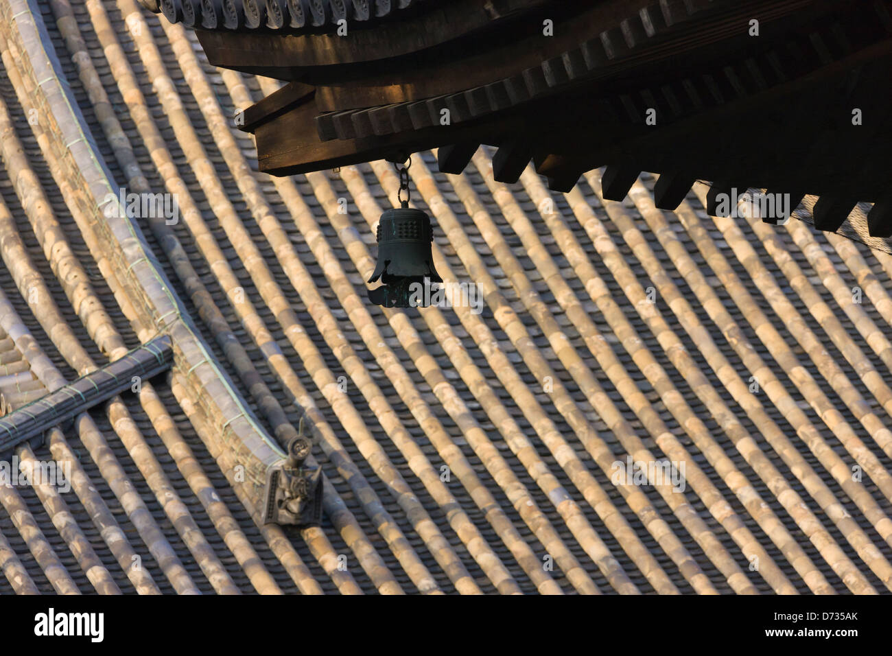 Tetto di tegole con campana di bronzo nel Tempio Toji, Kyoto, Giappone Foto Stock