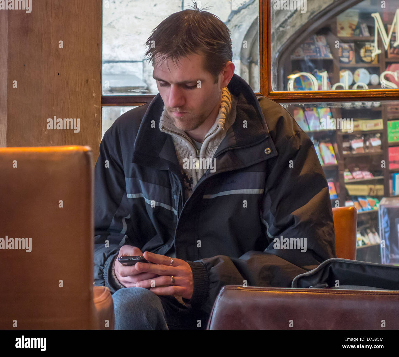 L'uomo texting nel coffee shop utilizzando il telefono cellulare Foto Stock
