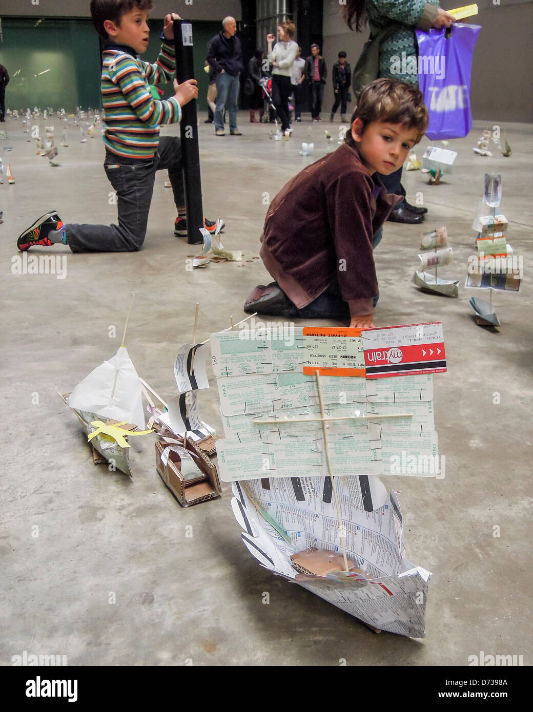 Susan Stockwell's Sail Away progetto presso la Tate Modern come parte della serie il collegamento ipertestuale il 27 e 28 aprile. Sail Away è una grande installazione di scala con centinaia di piccole imbarcazioni realizzate dalla carta moneta, biglietti, aghi da maglia e mappe. Basato sulle idee di connessioni tramite agenzia di viaggio, scambi commerciali e rotte, mappatura e coloniali/storie personali, salpate invita i bambini a interagire con il lavoro aggiungendo le proprie imbarcazioni per la flottiglia. La Tate Modern di Londra, UK, 27 aprile 2013. Foto Stock