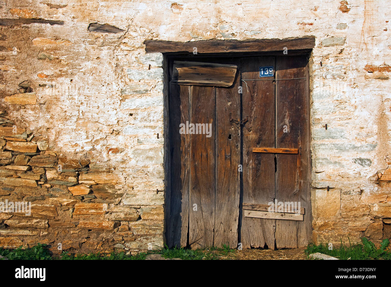 Sgangherate porta di legno nella vecchia casa di pietra anteriore (Grecia) Foto Stock