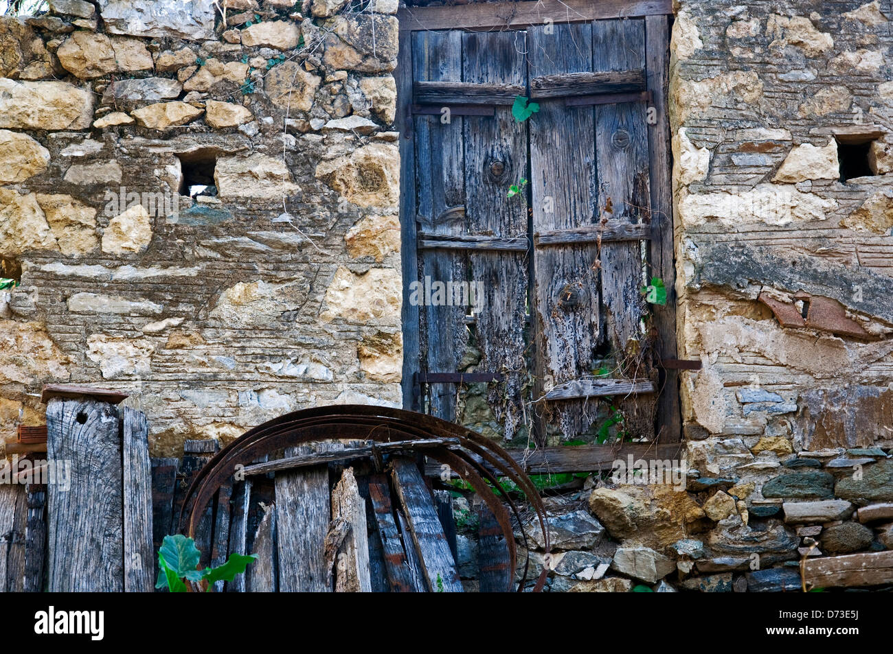 Sgangherate porta di legno nella vecchia casa di pietra anteriore (Grecia) Foto Stock