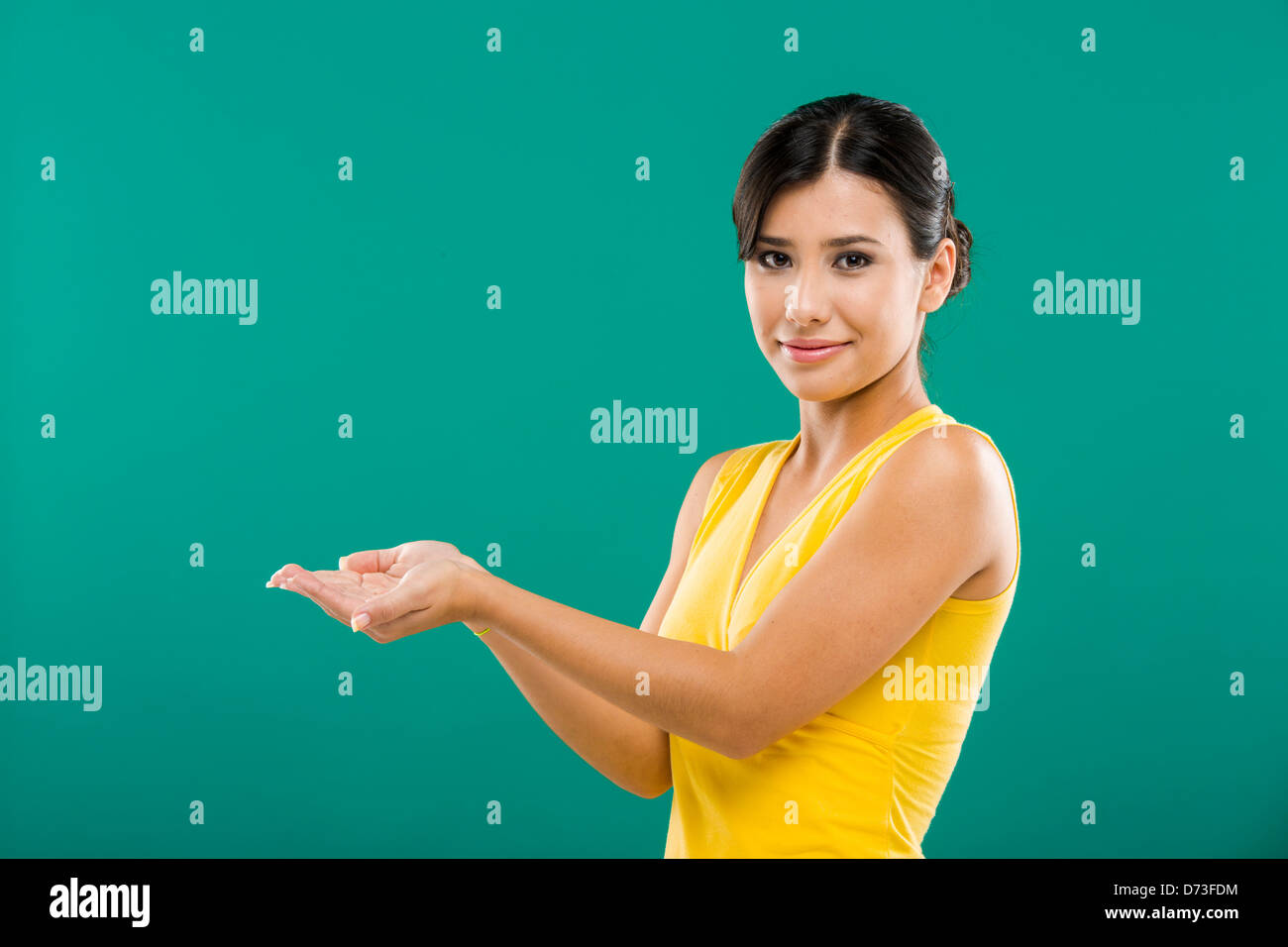 Bella donna asiatica che mostra il palmo delle mani, su uno sfondo verde Foto Stock