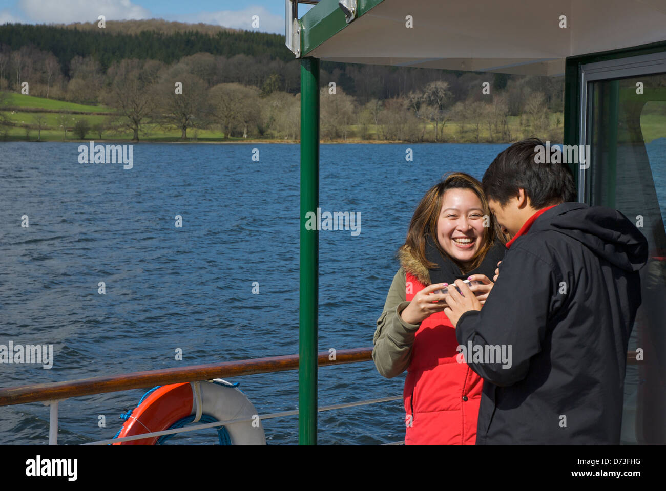 Giovani asiatici giovane passeggero sul sistema di cottura a vapore sul Lago di Windermere, Parco Nazionale del Distretto dei Laghi, Cumbria, England Regno Unito Foto Stock