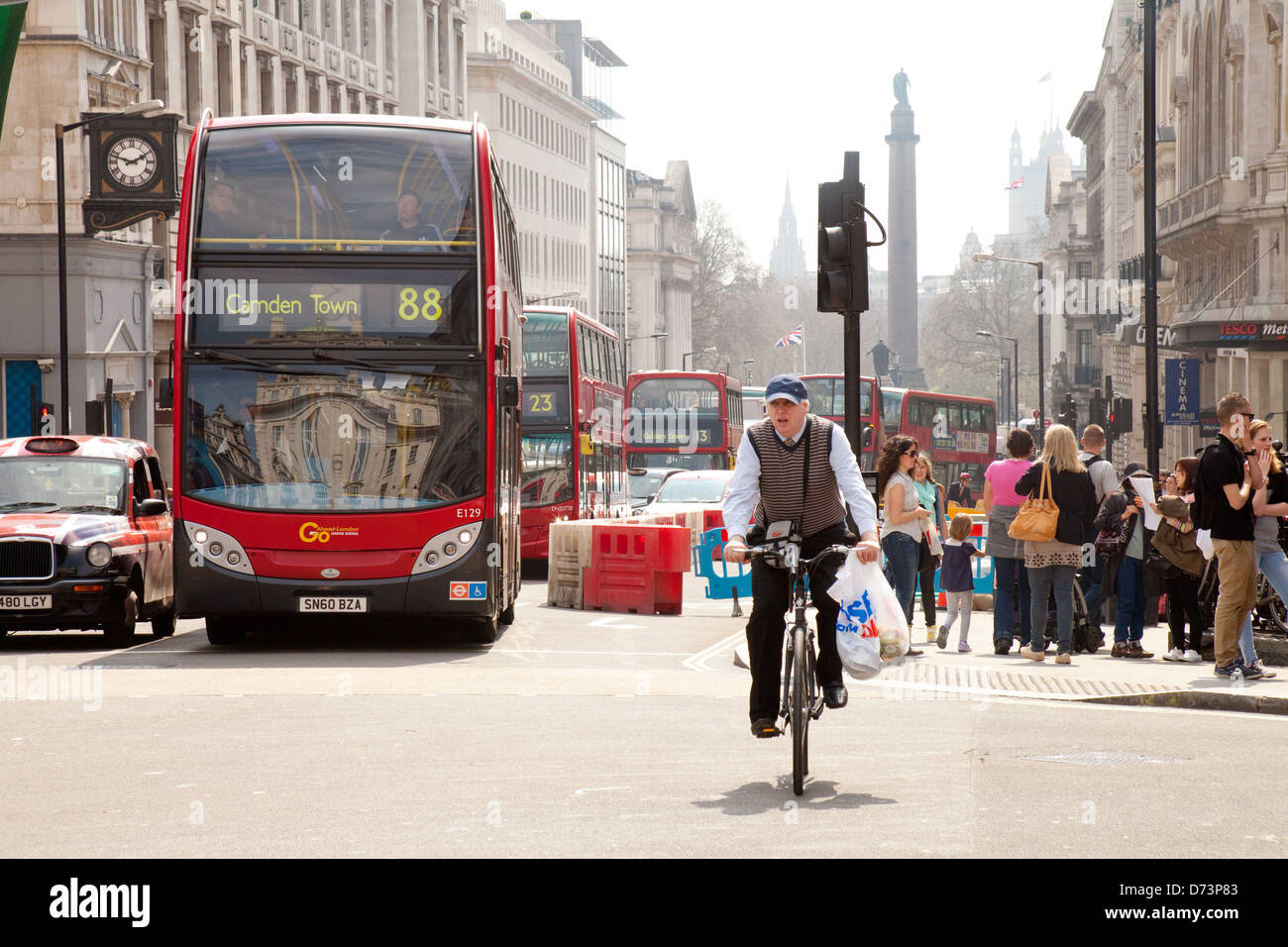 Un uomo in bicicletta la sua bicicletta a Piccadilly Circus, Central London W1, Regno Unito Foto Stock