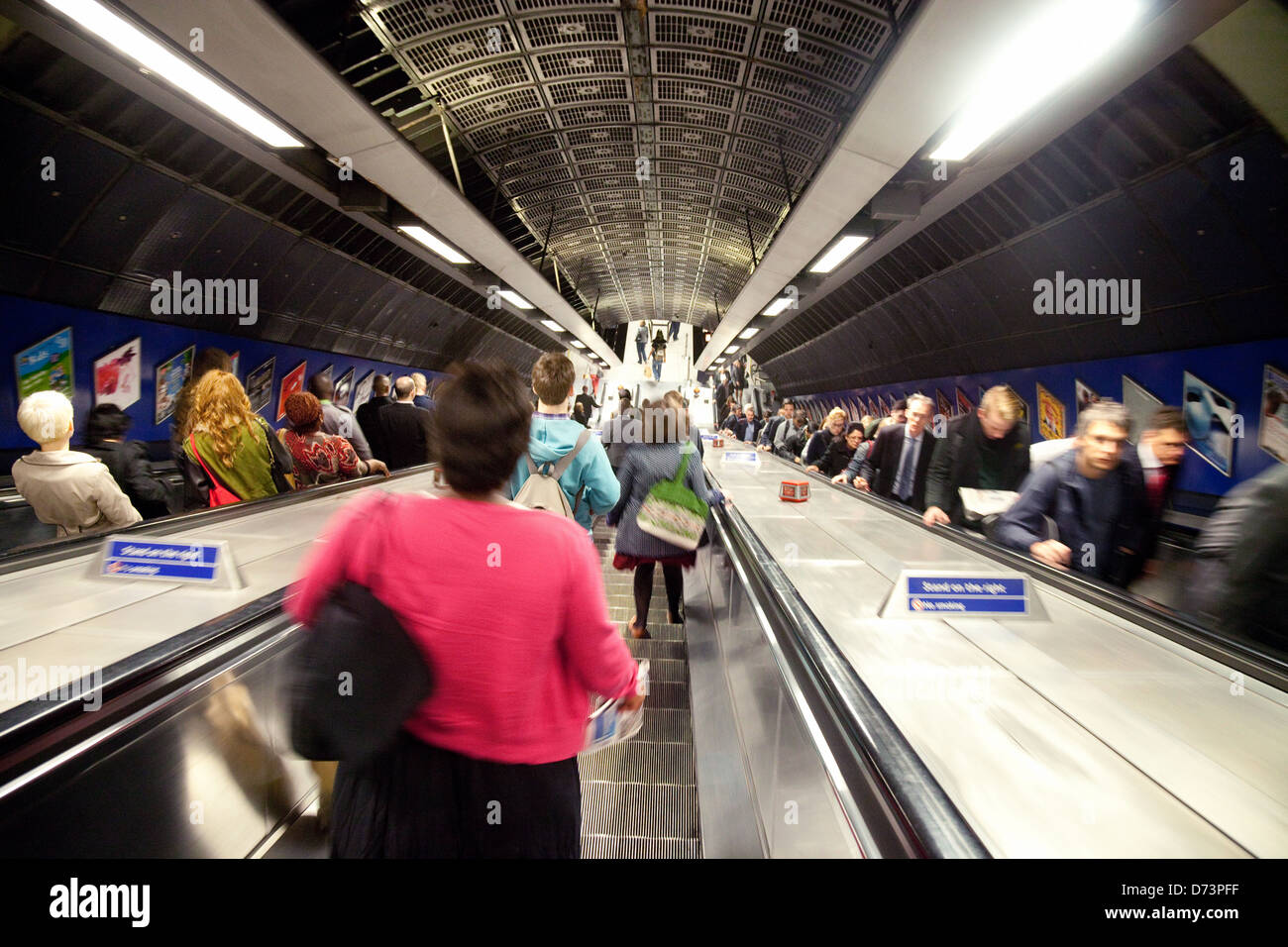 Pendolari pendolarismo per lavorare su scale mobili, la metropolitana di Londra la metropolitana, la stazione di London Bridge, Regno Unito Foto Stock