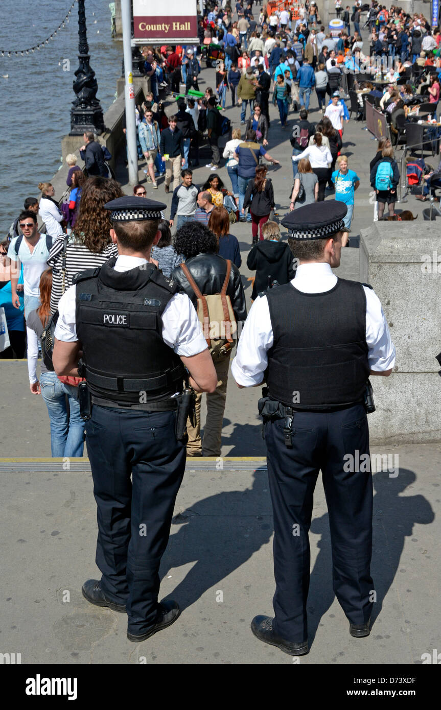 Metropolitan poliziotti guardando la folla di turisti su County Hall riverside south bank Foto Stock