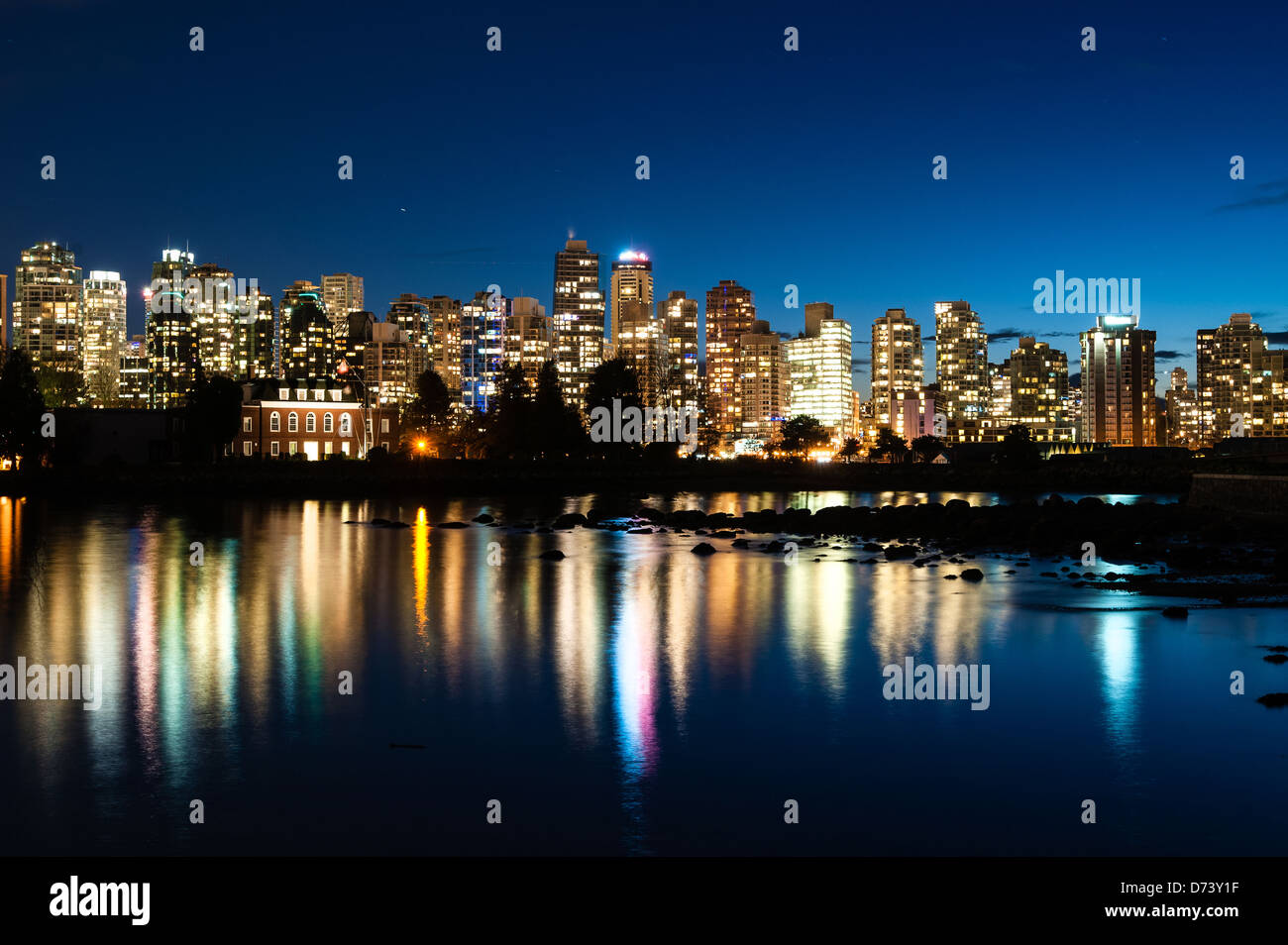 Paesaggio urbano del centro cittadino di Vancouver, BC, Canada durante il crepuscolo (impostazione sun). Serena riflessione della città sull'acqua. Foto Stock