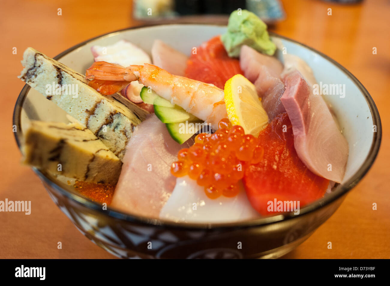 Ciotola di Chirashi Sushi con fresca selezione di tamago, salmone, tonno, pesce roe, Saba, wasabi, polpo su un letto di riso sushi. Foto Stock