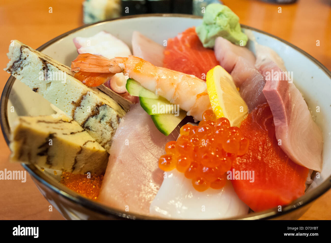 Ciotola di Chirashi Sushi con fresca selezione di tamago, salmone, tonno, pesce roe, Saba, wasabi, polpo su un letto di riso sushi. Foto Stock