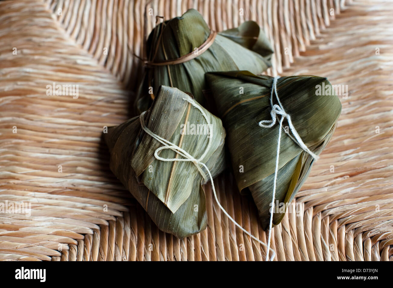 Zongzi (粽子) è un bambù o reed lascia avvolto di riso appiccicoso gnocco mangiato durante il drago cinese Boat Festival. Foto Stock
