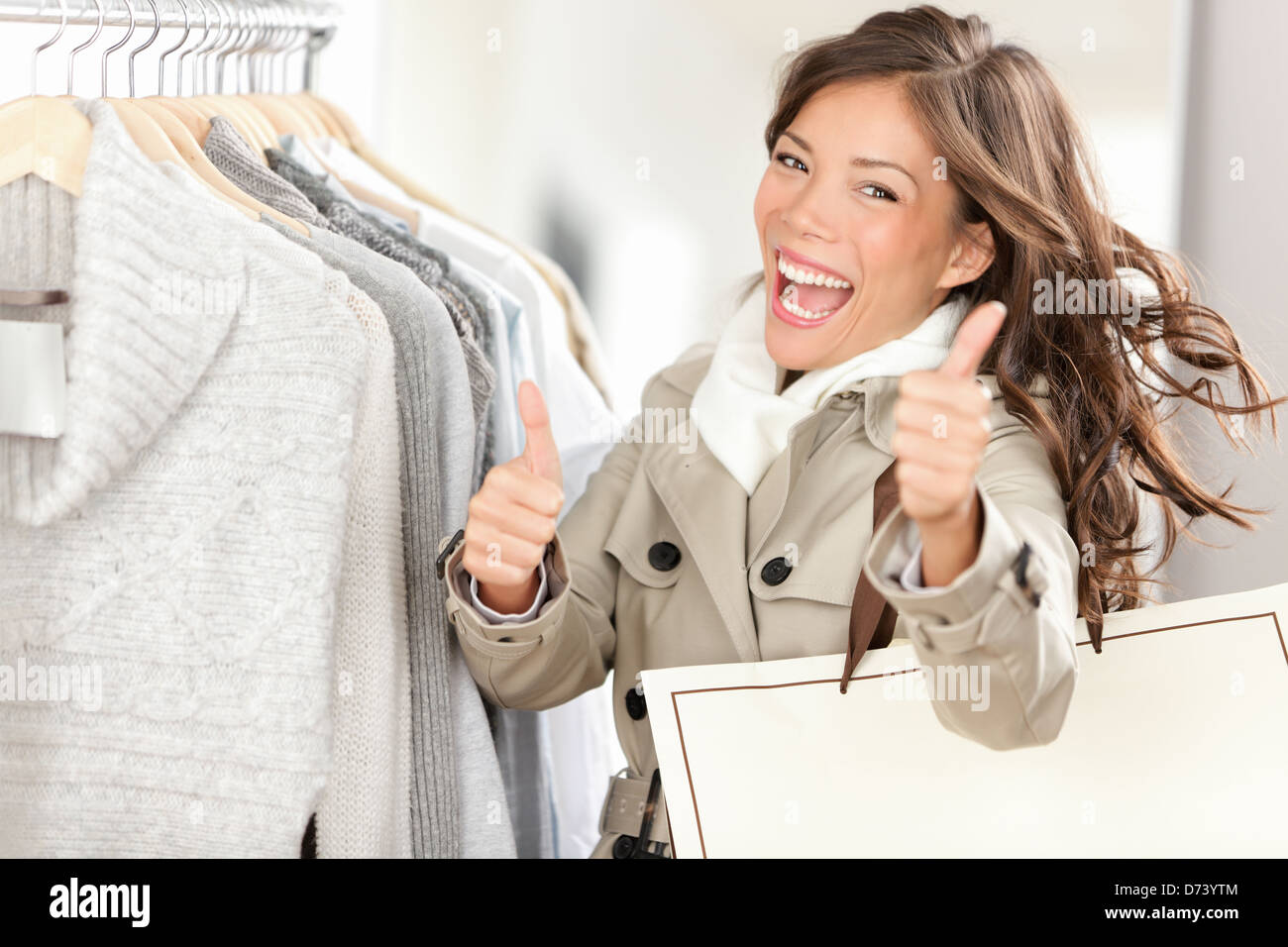 Shopper donna felice shopping e acquistare vestiti. Gioiosa Excited donna sorridente - misti razza caucasica Cinese / Asian modello femminile azienda shopping bag Foto Stock