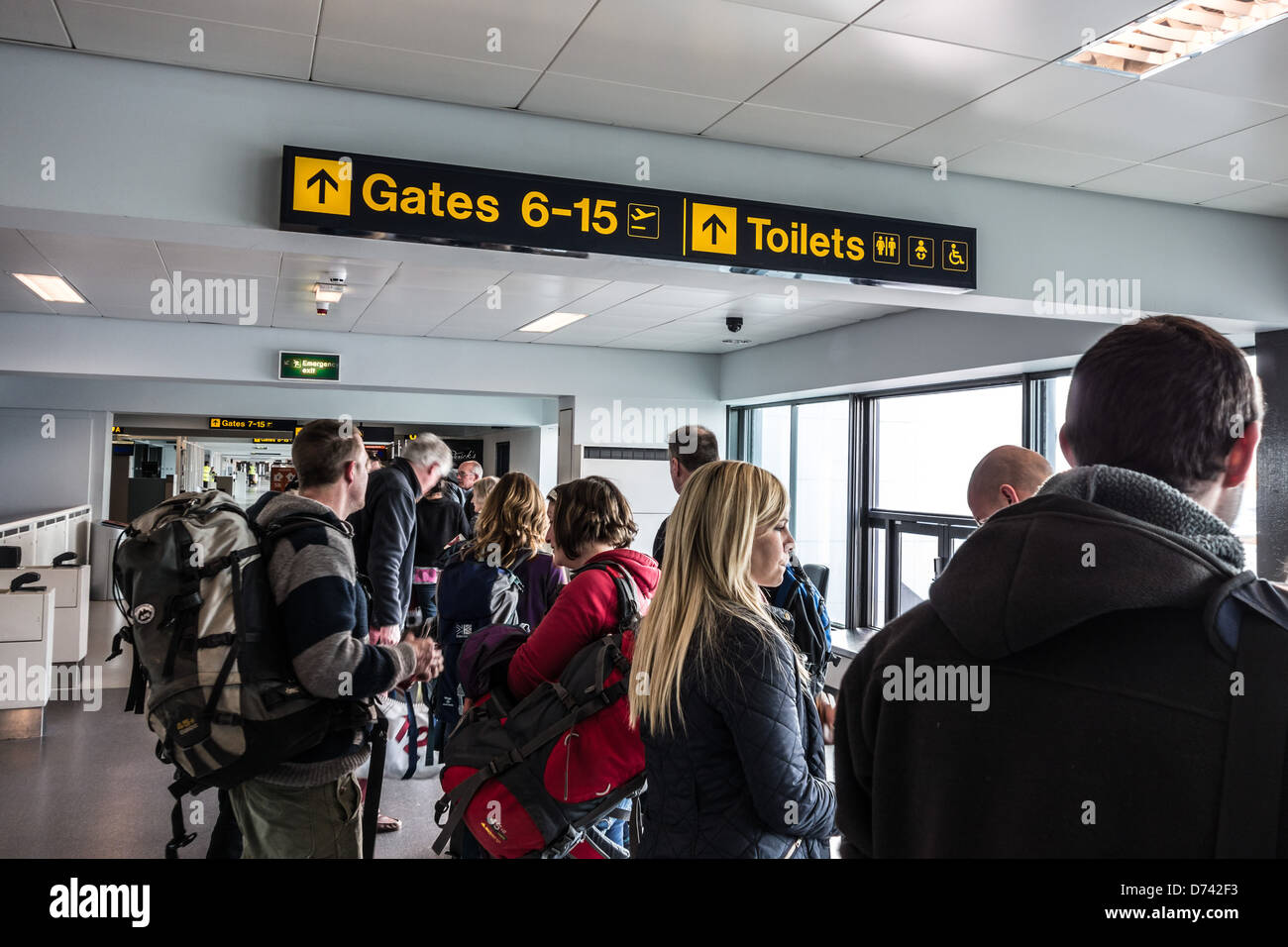 Aeroporto di Manchester - Easyjet gate di partenza, i clienti con il bagaglio al seguito. In viaggio per il Marocco. Foto Stock