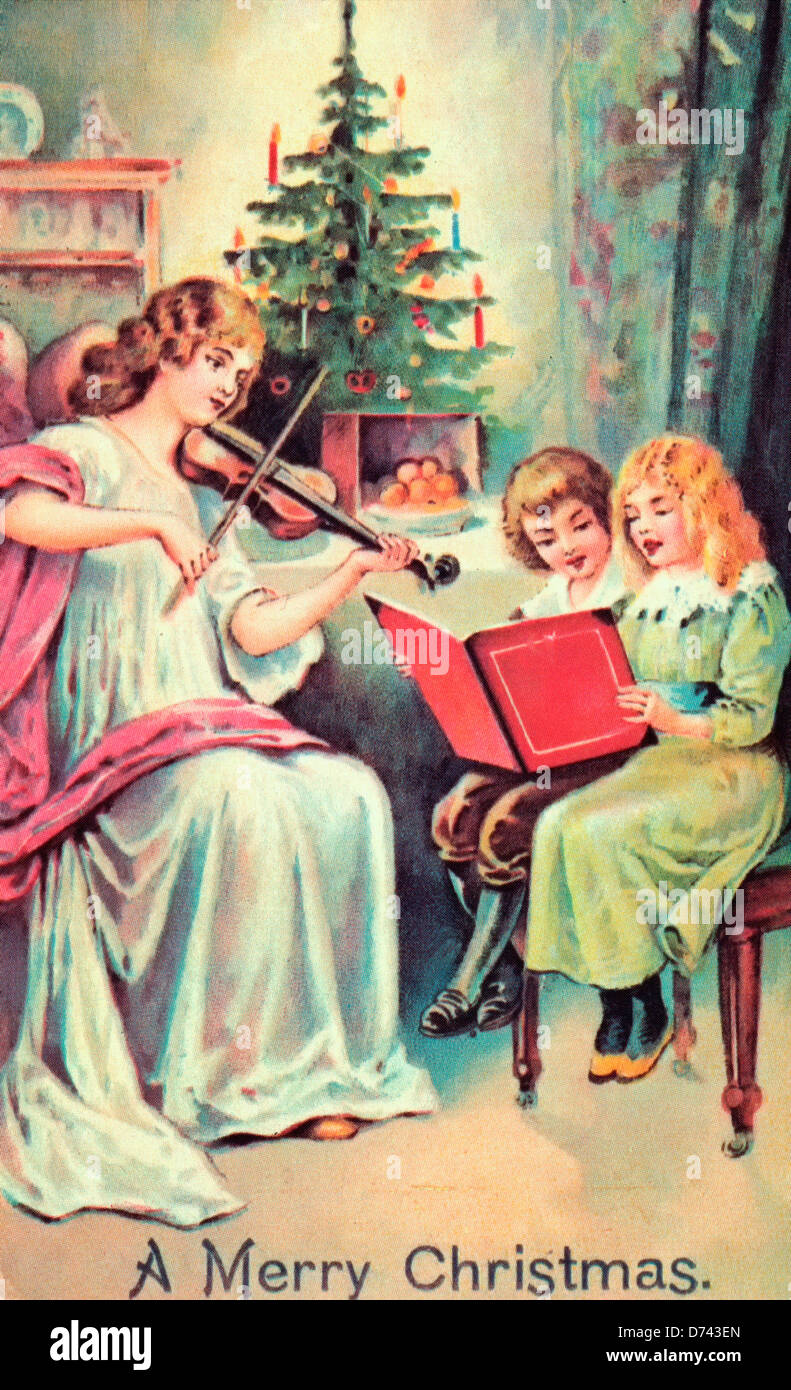 Un Buon Natale - donna suona il violino mentre i bambini cantano, scheda vintage Foto Stock