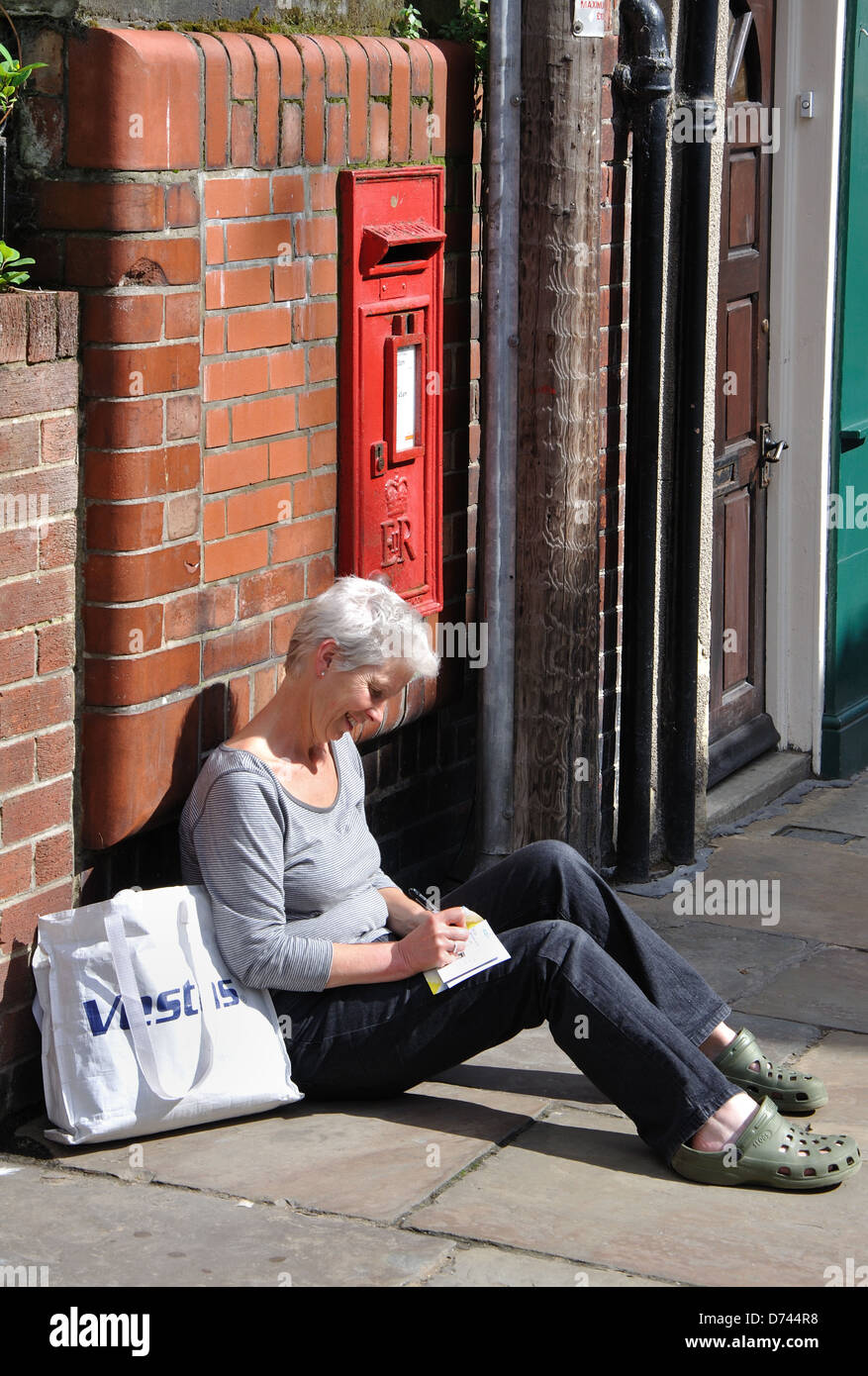 Donna cartolina di scrittura, Whitby, nello Yorkshire, Inghilterra, Regno Unito Foto Stock