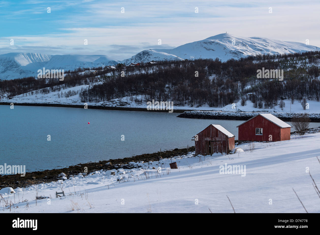 Due vecchi edifici in legno sulla riva in una baia in Norvegia Foto Stock